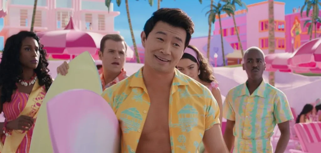 Simu Liu holding a surfboard in Barbie- Illustration photo from the article Fortune Simu Liu