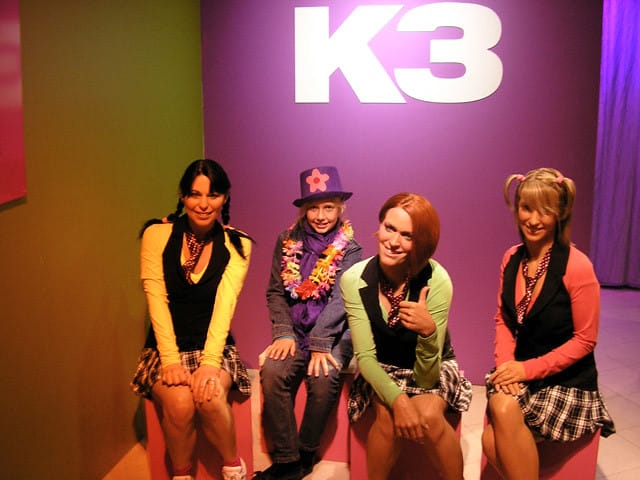 The music group K3, a popular Studio 100 franchise, evokes the cultural impact of Hans Bourlon and Gert Verhulst.