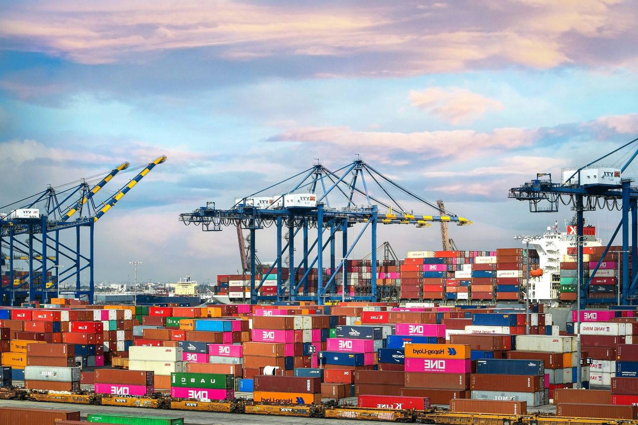  Een bruisende haven van containers, die de wereldwijde invloed van Fernand Huts in de logistieke en transportsector belichaamt.