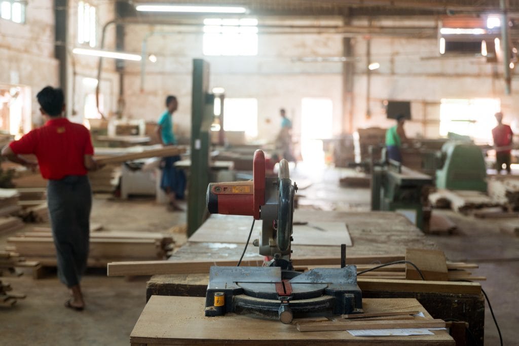 Wood-cutting machine in a Mintjens factory, a symbol of precision craftsmanship in the creation of oak furniture.