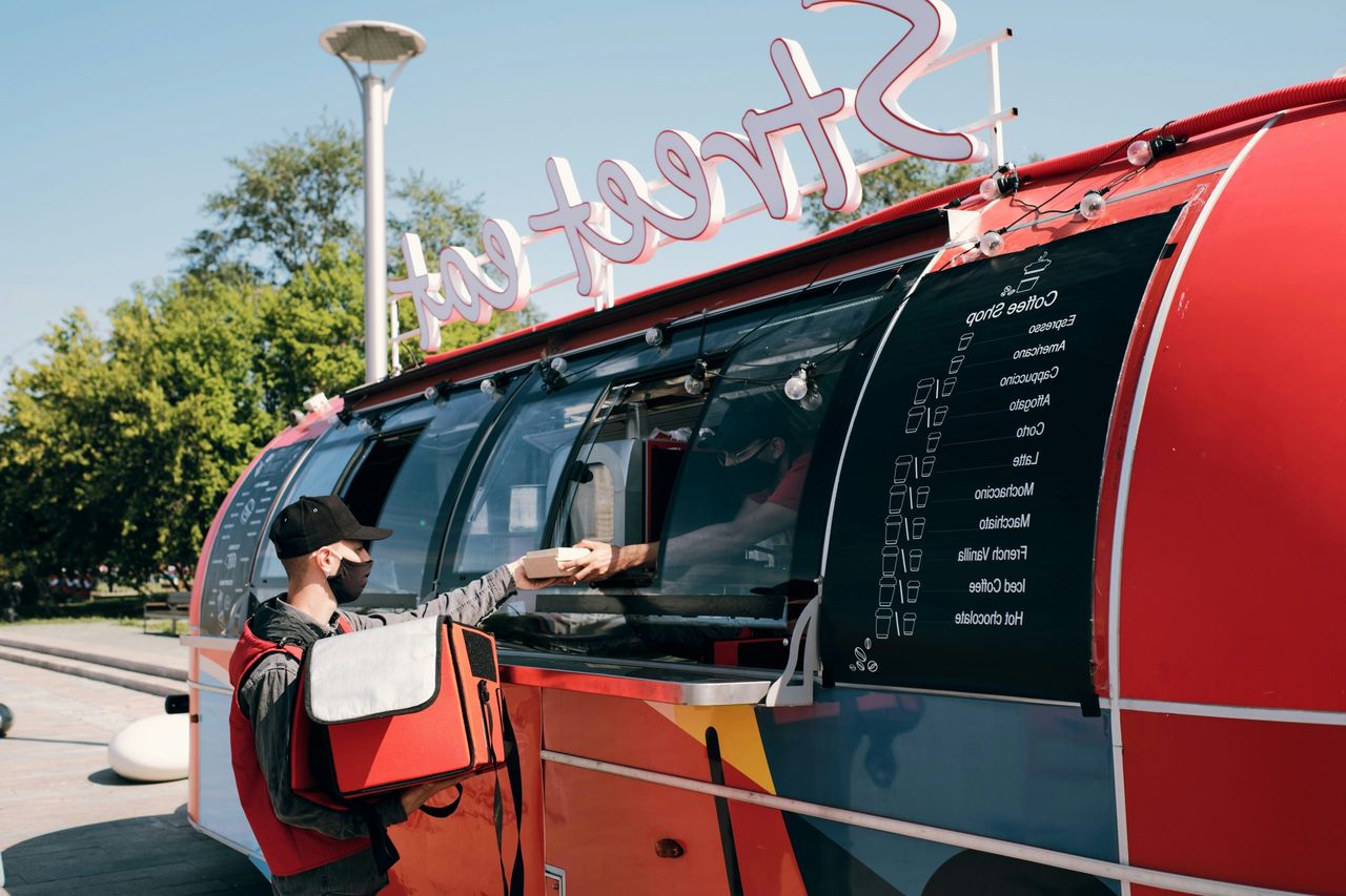 Modern food truck serving a customer, an extension of Stephan Conter's entrepreneurial empire in mobile catering.