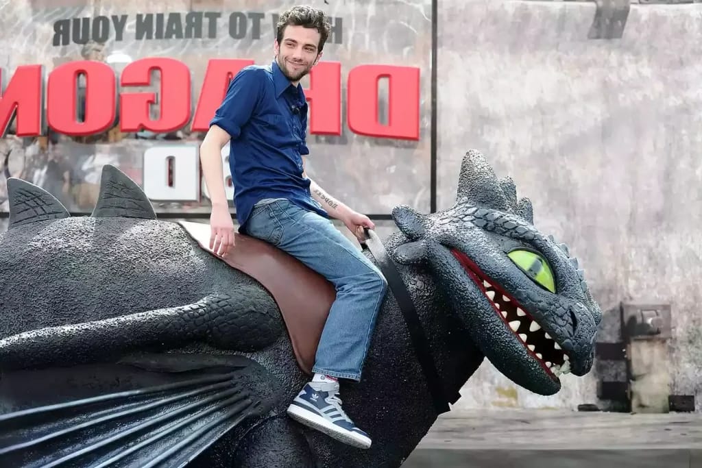Jay Baruchel auf dem Rücken einer Nachbildung des Drachen Ohnezahn - Illustrationsfoto des Artikels Vermögen Jay Baruchel